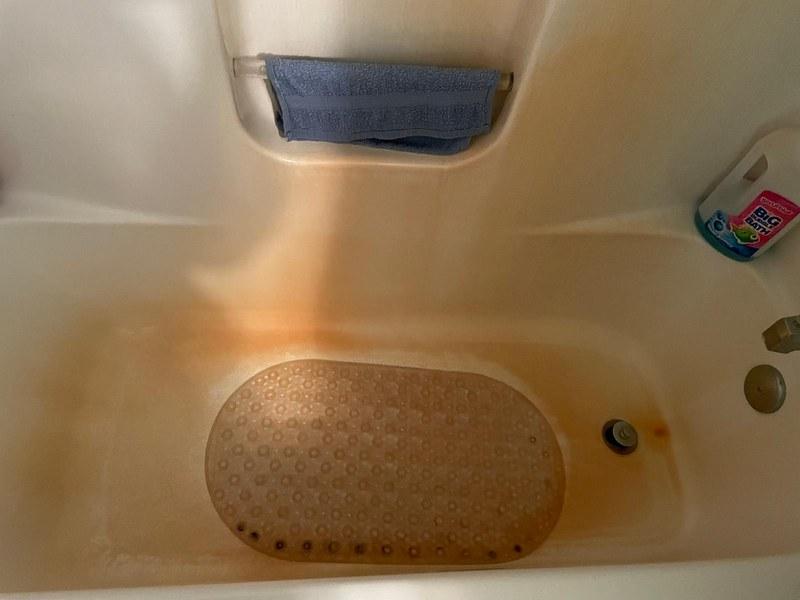 Before — Orange stained tub